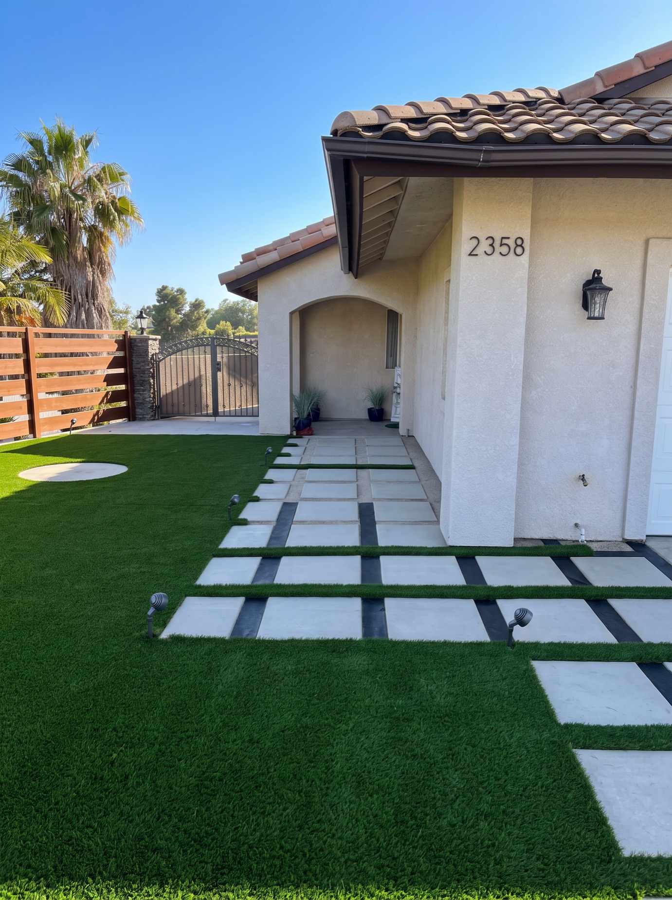 Concrete paver and turf walkway with landscape lighting at twilight